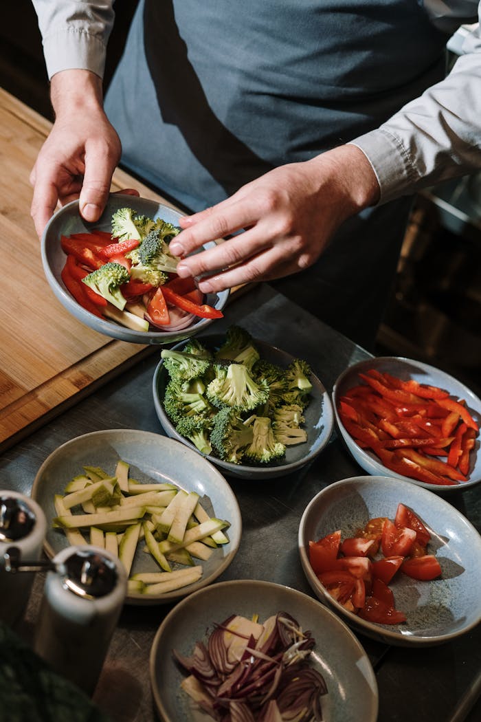 A professional chef prepares fresh vegetable plates in a modern kitchen setting.
